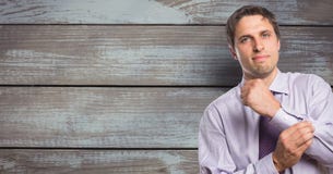 Portrait of confident businessman buttoning sleeve against wooden wall stock photos Portrait of confident businessman buttoning sleeve against wooden wall stock photos