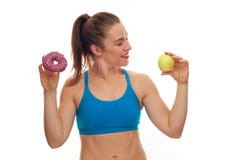 Sportive woman choosing between donut and apple stock images Sportive woman choosing between donut and apple stock images