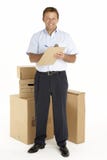 Portrait Of Courier Standing Next To Parcels