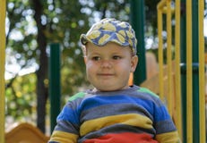 Cute fat European boy on a children`s slide stock image Cute fat European boy on a children`s slide stock image