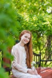 Portrait of a cute girl with long red hair in the park stock images Portrait of a cute girl with long red hair in the park stock images