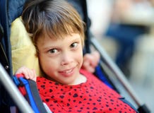 Portrait of a cute little disabled girl in a wheelchair. Child cerebral palsy. Inclusion