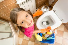 Portrait of cute little girl cleaning toilet with brush royalty free stock photo Portrait of cute little girl cleaning toilet with brush royalty free stock photo