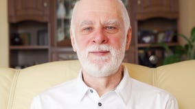 Portrait d'homme supérieur de sourire bel bel dans le T-shirt blanc de polo se reposant sur le sofa à la maison banque de vidéos Portrait d'homme supérieur de sourire bel bel dans le T-shirt blanc de polo se reposant sur le sofa à la maison banque de vidéos