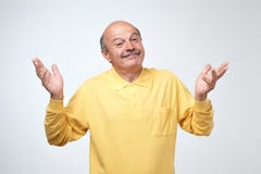 Portrait d'intérieur d'homme supérieur confus dans l'apparence jaune de T-shirt je n'ai aucun geste d'idée photo libre de droits Portrait d'intérieur d'homme supérieur confus dans l'apparence jaune de T-shirt je n'ai aucun geste d'idée photo libre de droits