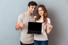 Portrait d'un couple se dirigeant à l'ordinateur portable d'écran vide Images libres de droits Portrait d'un couple se dirigeant à l'ordinateur portable d'écran vide Images libres de droits