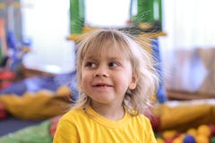 Portrait d'un garçon blond dans un T-shirt jaune Les sourires et les jeux d'enfant dans la salle de jeux des enfants images stock Portrait d'un garçon blond dans un T-shirt jaune Les sourires et les jeux d'enfant dans la salle de jeux des enfants images stock