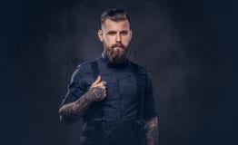 Portrait d'un hippie démodé beau dans une chemise bleue et des bretelles, posant dans un studio image stock Portrait d'un hippie démodé beau dans une chemise bleue et des bretelles, posant dans un studio image stock