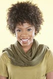 Portrait d'une femme d'Afro-américain souriant avec une étole ronde son cou au-dessus de fond coloré photos stock Portrait d'une femme d'Afro-américain souriant avec une étole ronde son cou au-dessus de fond coloré photos stock