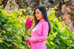 Portrait d'une jeune adolescente portant un rose en parc photo stock Portrait d'une jeune adolescente portant un rose en parc photo stock