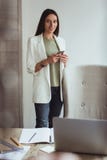 Portrait d'une jeune femme d'affaires s'asseyant avec son ordinateur portable dans le bureau photos stock Portrait d'une jeune femme d'affaires s'asseyant avec son ordinateur portable dans le bureau photos stock