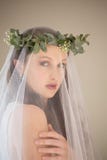 Portrait de belle jeune mariée dans la robe de mariage et le mur se tenant prêt de diadème à la maison photo libre de droits Portrait de belle jeune mariée dans la robe de mariage et le mur se tenant prêt de diadème à la maison photo libre de droits