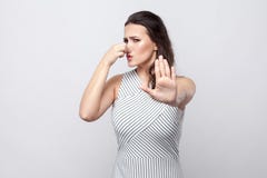 Portrait de bloquer la jeune femme de brune de femme avec le maquillage et la position rayée de robe avec le geste d'arrêt et de image libre de droits Portrait de bloquer la jeune femme de brune de femme avec le maquillage et la position rayée de robe avec le geste d'arrêt et de image libre de droits