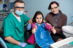 Portrait de dentiste et de fille pédiatriques supérieurs avec sa mère lors de la première visite dentaire au bureau dentaire photo libre de droits Portrait de dentiste et de fille pédiatriques supérieurs avec sa mère lors de la première visite dentaire au bureau dentaire photo libre de droits