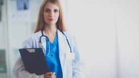 Portrait de docteur de femme avec le dossier au couloir d'hôpital image stock Portrait de docteur de femme avec le dossier au couloir d'hôpital image stock
