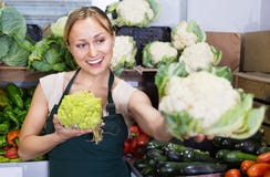 Portrait de femme travaillant dans la boutique de fruit montrant le chou frais Photo stock Portrait de femme travaillant dans la boutique de fruit montrant le chou frais Photo stock