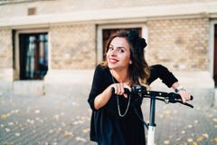 Portrait de fille souriant et montant le scooter électrique Photographie stock Portrait de fille souriant et montant le scooter électrique Photographie stock