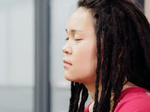 Portrait de jeune femelle chinoise avec les dreadlocks mignons et le visage réfléchi se reposant et méditant avec des yeux fermés photo stock Portrait de jeune femelle chinoise avec les dreadlocks mignons et le visage réfléchi se reposant et méditant avec des yeux fermés photo stock