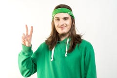 Portrait de jeune homme bel dans le hoodie vert avec un sourire paisible, regardant dans l'appareil-photo et montrant le signe de image stock Portrait de jeune homme bel dans le hoodie vert avec un sourire paisible, regardant dans l'appareil-photo et montrant le signe de image stock