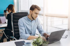 Portrait de jeune homme se reposant à son bureau dans le bureau images libres de droits Portrait de jeune homme se reposant à son bureau dans le bureau images libres de droits