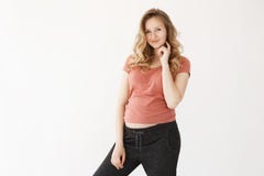 Portrait de jeune mère heureuse avec les cheveux blonds dans le T-shirt rouge occasionnel et des pantalons noirs tenant la main p images stock Portrait de jeune mère heureuse avec les cheveux blonds dans le T-shirt rouge occasionnel et des pantalons noirs tenant la main p images stock