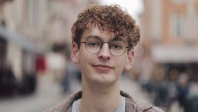 Portrait de jeune type de hippie avec des verres se tenant sur la rue de ville et regardant dans la caméra De touristes, voyage banque de vidéos Portrait de jeune type de hippie avec des verres se tenant sur la rue de ville et regardant dans la caméra De touristes, voyage banque de vidéos