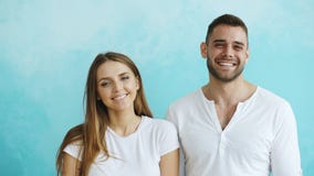 Portrait de jeunes couples heureux souriant et riant dans l'appareil-photo sur le fond bleu Photos stock Portrait de jeunes couples heureux souriant et riant dans l'appareil-photo sur le fond bleu Photos stock