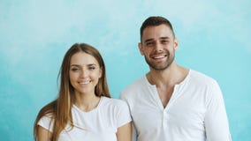 Portrait de jeunes couples heureux souriant et riant dans l'appareil-photo sur le fond bleu Images stock Portrait de jeunes couples heureux souriant et riant dans l'appareil-photo sur le fond bleu Images stock