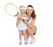 Portrait de mère heureuse et de bébé tenant la raquette de tennis Photographie stock libre de droits Portrait de mère heureuse et de bébé tenant la raquette de tennis Photographie stock libre de droits
