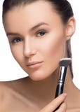 Portrait de plan rapproché d'une femme appliquant la base tonale cosmétique sèche sur le visage utilisant la brosse de maquillage photographie stock Portrait de plan rapproché d'une femme appliquant la base tonale cosmétique sèche sur le visage utilisant la brosse de maquillage photographie stock