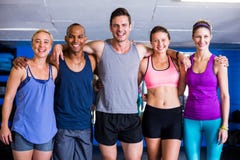Portrait des amis de sourire avec le bras autour dans le gymnase photos libres de droits Portrait des amis de sourire avec le bras autour dans le gymnase photos libres de droits