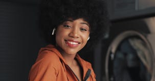 Portrait des ?couteurs de port de jeune femme heureuse d'Afro-am?ricain regardant dans la cam?ra Blanchisserie publique de libre banque de vidéos Portrait des ?couteurs de port de jeune femme heureuse d'Afro-am?ricain regardant dans la cam?ra Blanchisserie publique de libre banque de vidéos