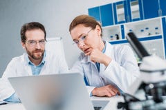 portrait des scientifiques dans des manteaux et des lunettes de laboratoire fonctionnant ensemble sur le lieu de travail avec l'o image stock portrait des scientifiques dans des manteaux et des lunettes de laboratoire fonctionnant ensemble sur le lieu de travail avec l'o image stock