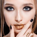 Portrait en gros plan de femme de beauté Le maquillage et la manucure professionnels avec la feuille d'or, smokey observe Couleur photo libre de droits Portrait en gros plan de femme de beauté Le maquillage et la manucure professionnels avec la feuille d'or, smokey observe Couleur photo libre de droits