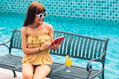 Portrait of an Exited young asians girl looking her mobile phone,smart phone ot tablet sit on chair royalty free stock images Portrait of an Exited young asians girl looking her mobile phone,smart phone ot tablet sit on chair royalty free stock images