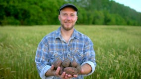 Portrait of farmer holding in hands biological product of potatoes. Concept - Farmer`s market, Organic Farming, Farm