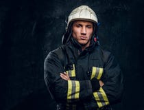 Brutal fireman in uniform posing for the camera standing with crossed arms and confident look. stock photos Brutal fireman in uniform posing for the camera standing with crossed arms and confident look. stock photos