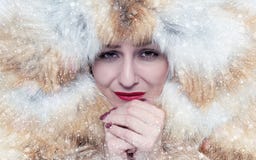 Portrait of a frozen young girl in a fox fur coat, warm her hands, cold, snow, frost, blizzard stock photo Portrait of a frozen young girl in a fox fur coat, warm her hands, cold, snow, frost, blizzard stock photo