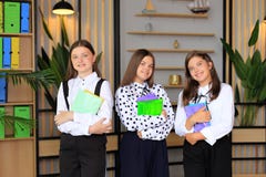 Portrait of girls in school uniforms with books in their hands.