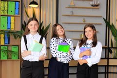 Portrait of girls in school uniforms with books in their hands.