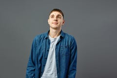 Portrait guy dressed in white t-shirt and a jeans shirt on the gray background in the studio royalty free stock image Portrait guy dressed in white t-shirt and a jeans shirt on the gray background in the studio royalty free stock image