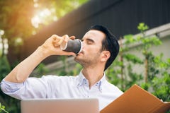 Portrait of handsome successful man drink coffee. Happy man take coffee break as he sitting at his laptop computer working Stock Photo Portrait of handsome successful man drink coffee. Happy man take coffee break as he sitting at his laptop computer working Stock Photo