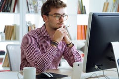 Handsome young businessman using his laptop in the office. Royalty Free Stock Images Handsome young businessman using his laptop in the office. Royalty Free Stock Images