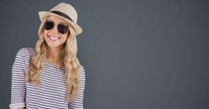 Portrait of happy female hipster wearing sunglasses and sun hat against gray background