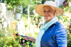 Portrait of happy gardener watering from hose at garden royalty free stock photos Portrait of happy gardener watering from hose at garden royalty free stock photos