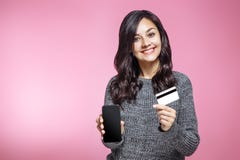 Portrait of a happy girl holding blank screen mobile phone and showing credit card over pink background royalty free stock photos Portrait of a happy girl holding blank screen mobile phone and showing credit card over pink background royalty free stock photos