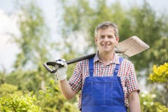 Portrait of happy man carrying spade on shoulder in plant nursery stock image Portrait of happy man carrying spade on shoulder in plant nursery stock image