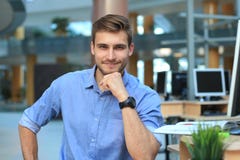 Portrait of happy man sitting at office desk, looking at camera, smiling. royalty free stock photography Portrait of happy man sitting at office desk, looking at camera, smiling. royalty free stock photography