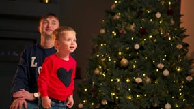 Portrait of happy mother and adorable baby celebrate Christmas. New Year`s holidays. Toddler with mom in the festively stock video footage Portrait of happy mother and adorable baby celebrate Christmas. New Year`s holidays. Toddler with mom in the festively stock video footage