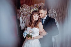 Portrait of happy young bride and groom in a classic interior near the dream catchers. Wedding day, love theme. First day of a new stock images Portrait of happy young bride and groom in a classic interior near the dream catchers. Wedding day, love theme. First day of a new stock images